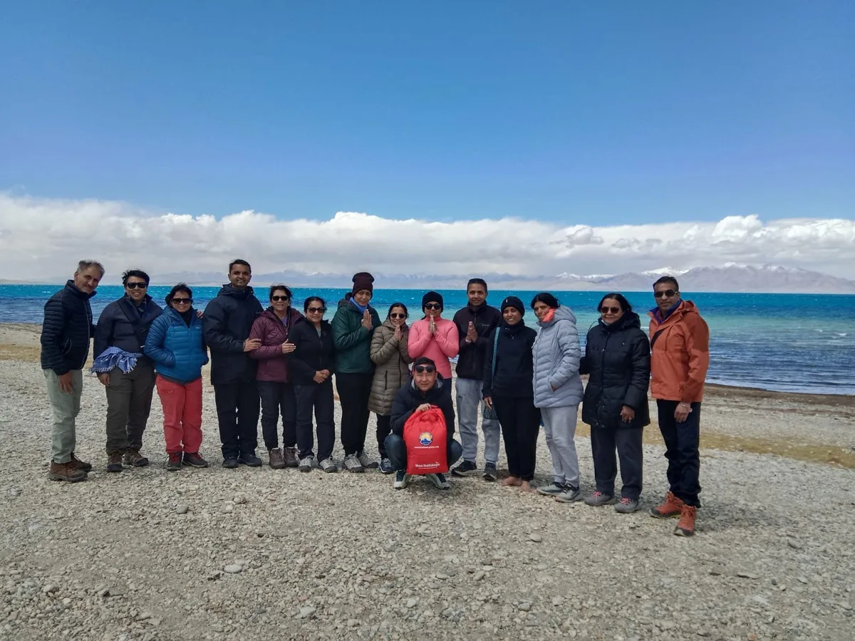 A group of pilgrims standing on the shore of Lake Mansarovar